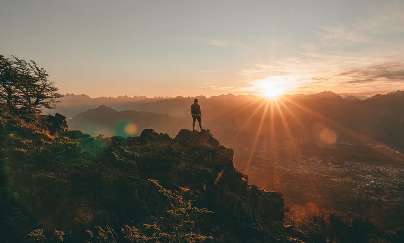 Person on top of mountain during sunset