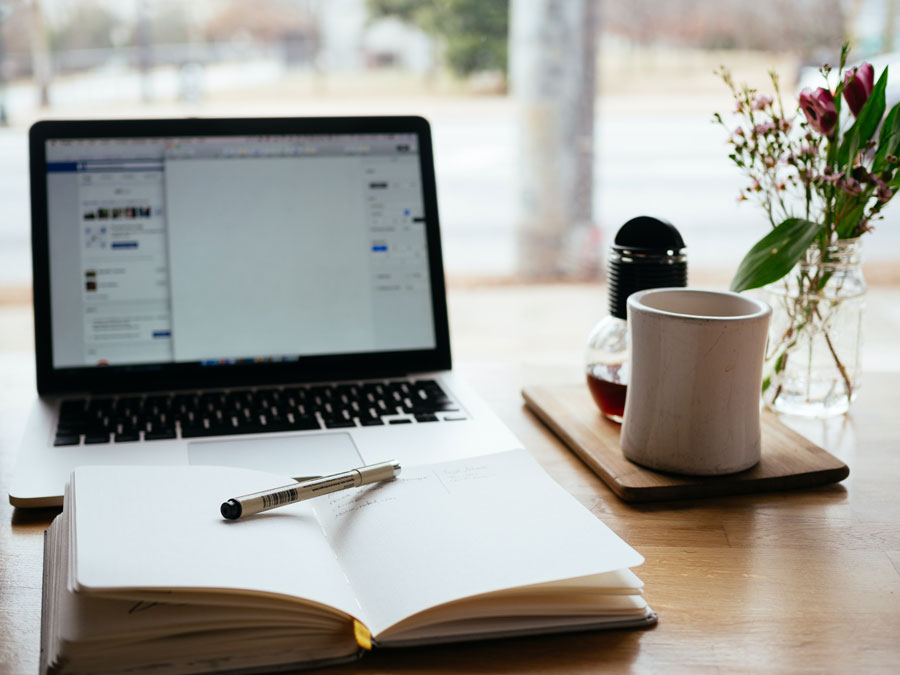 Desk with computer, notepad and mug